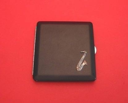 The Saxophone Black Faux Leather Cigarette Case is a stylish and practical accessory that adds a touch of sophistication to your smoking experience. Made from high-quality faux leather, it provides a sleek and durable housing for your cigarettes, keeping them safe and protected. The black color adds a touch of elegance, while the saxophone design adds a unique and artistic flair. Whether you are a smoker or simply appreciate fine craftsmanship, this cigarette case is a must-have accessory.