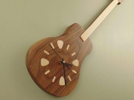 The wooden guitar clock made to order is a custom-made timepiece that combines the beauty of music and craftsmanship, creating a unique and personalized addition to any space.