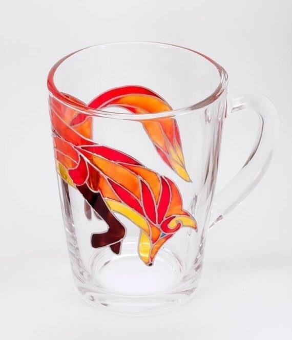 The Hand-Painted Fox Glass Mug is a beautifully designed drinkware item that features an intricate fox design painted by hand. It adds a touch of elegance and charm to any beverage experience.
