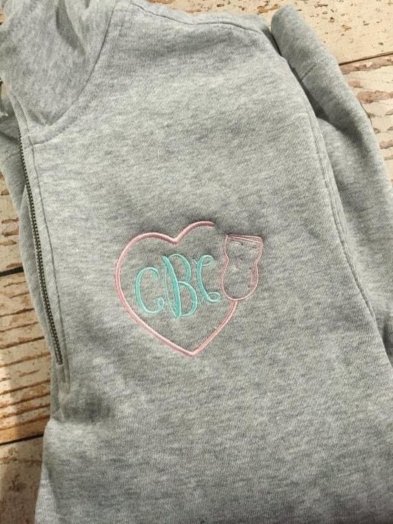 The Monogrammed Heart Shaped Wand and Cord Sweatshirt is a fashionable and personalized clothing item that features a unique heart-shaped design and a stylish cord detail, perfect for adding a touch of elegance to your outfit.