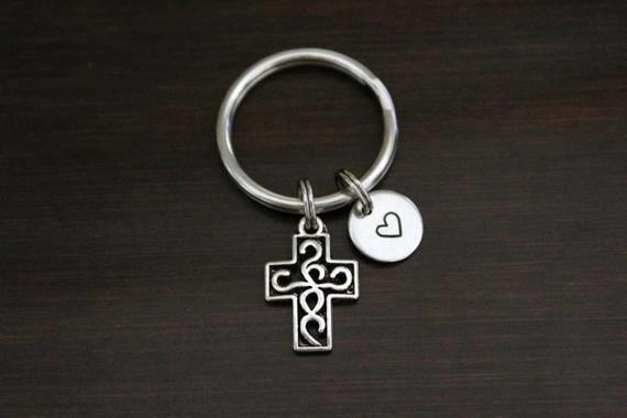 The Cross Keyring with Heart Charm is a beautiful accessory that symbolizes love and faith, making it a perfect gift for someone special.