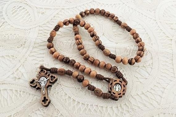 The Olive Wood and Leather Rosary is a beautifully crafted religious artifact, combining the natural beauty of olive wood with the elegance of leather, perfect for prayer and reflection.