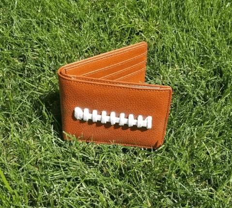 The Leather Football Bi-Fold Wallet is a stylish accessory that combines the love for football and the practicality of a wallet, making it a perfect choice for any football enthusiast or sports lover.