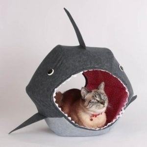 The Shark Cat Bed is a fun and cozy sleeping space for your feline friend, designed in the shape of a shark to add an element of playfulness to your home decor.