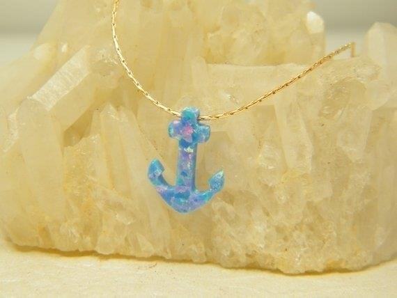 The Blue Opal Anchor on a Gold Necklace is a stunning piece of jewelry that exudes elegance and sophistication, perfect for any occasion.