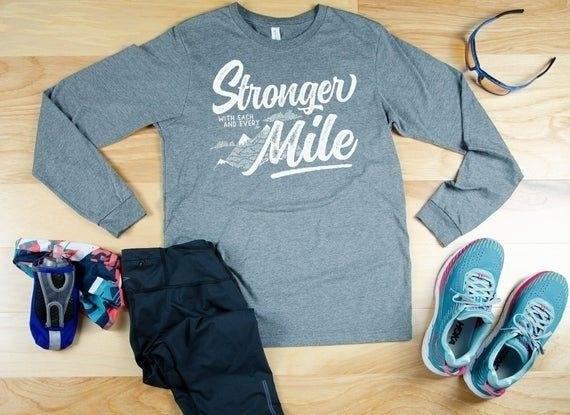 The KeenBeeStudio Stronger With Every Mile Long Sleeve T-shirt is a stylish and comfortable piece of clothing designed to keep you motivated and inspired as you conquer each mile of your journey.