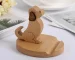 "A handcrafted wooden phone stand shaped like a dog"