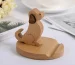 "A handcrafted wooden phone stand shaped like a dog"