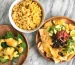 A plate of food with a bowl of macaroni and cheese, a plate of nachos, and a plate of broccoli.