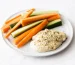 A round, white plate is covered in ingredients for a snack, including a vegan hemp hummus and raw crudites.