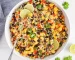 Overhead view on a large bowl of Brown rice and Quinoa Salad loaded with mango and vegetables.