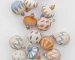 Painted earth tone wood ornaments on white background.