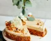 Raw Vegan Carrot Cake decorated with flowers, walnuts, shredded carrots, and raisins